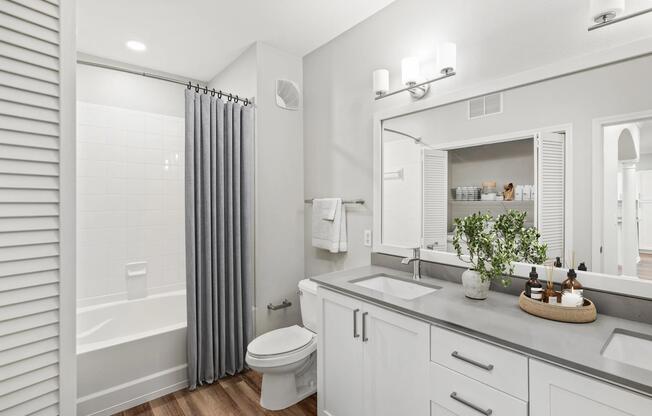 Bathroom with a double-sink vanity, quartz countertops, and ample storage, offering a functional layout designed for streamlined daily routines.