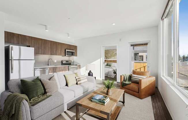 A modern living room with a grey couch, a wooden coffee table, and a large window.