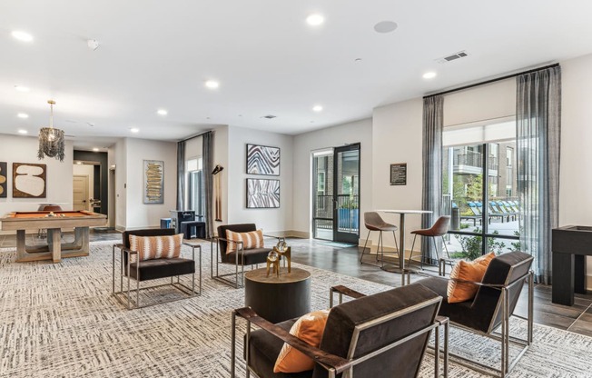 a living room with couches and chairs and a pool table