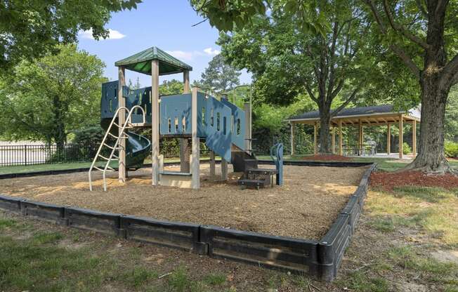 a playground with a blue playset and a swing set