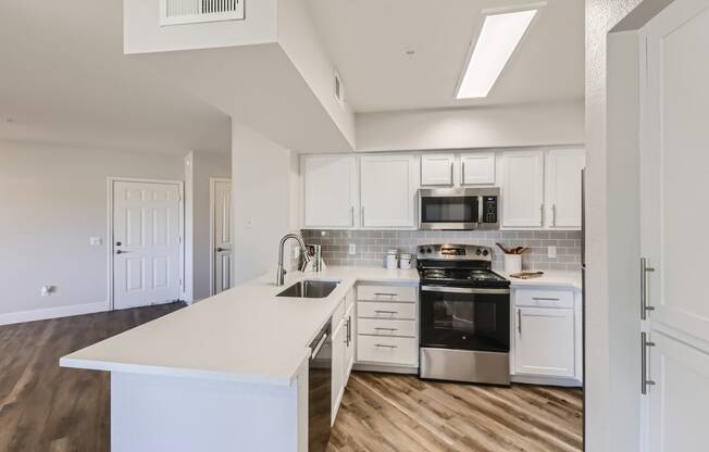 a kitchen with white cabinets and stainless steel appliances