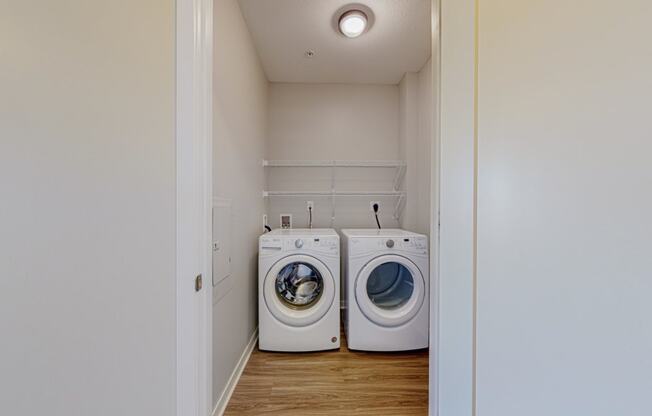 a designated laundry room with side by side washer and dryer and built in wire shelving