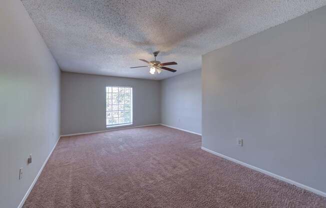 A room with a ceiling fan and a window.