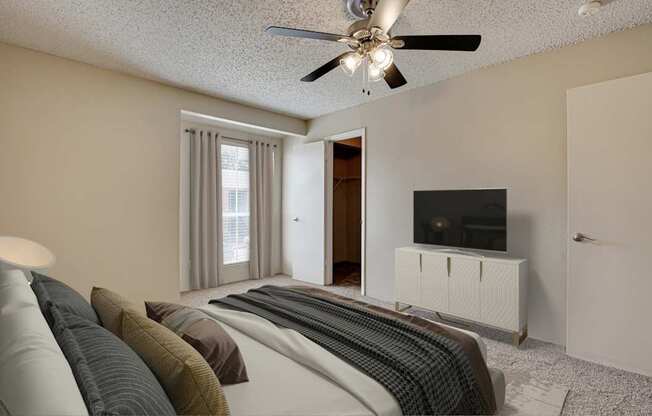 A living room with a grey sofa and a ceiling fan.