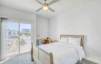 A bedroom with a large bed and a ceiling fan.
