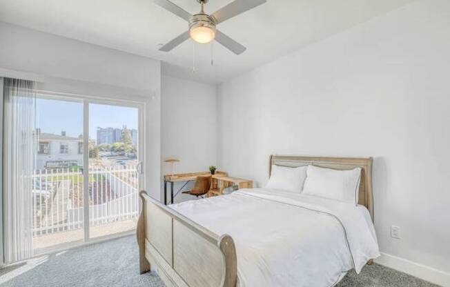 A bedroom with a large bed and a ceiling fan.