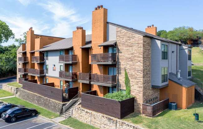 A modern apartment building with a parking lot in front.