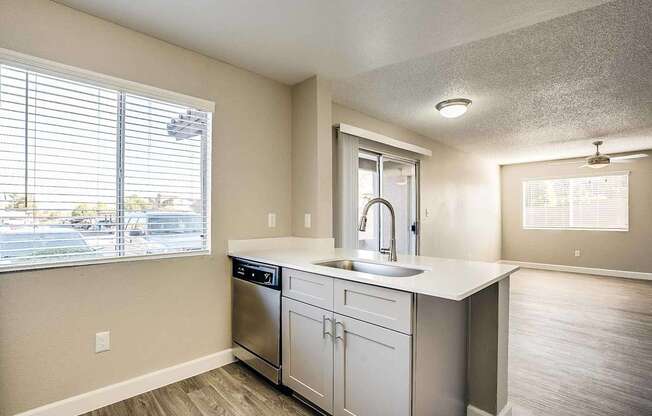 A kitchen with a stainless steel dishwasher and white countertops at Sterling Point Apartment Homes, Phoenix, AZ, 85042