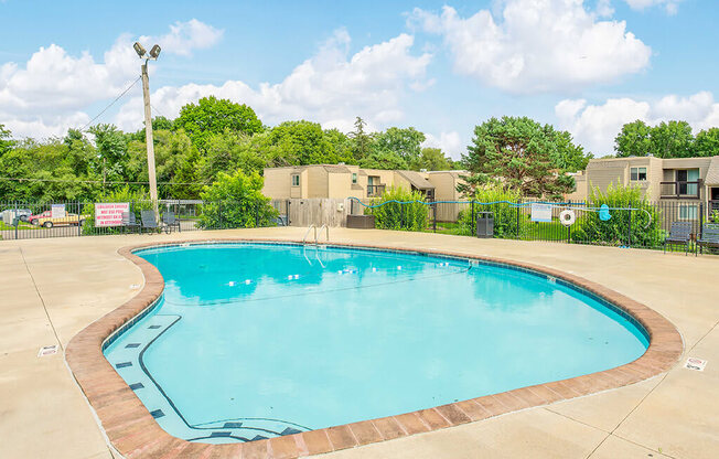 a resort style pool with trees and buildings in the background