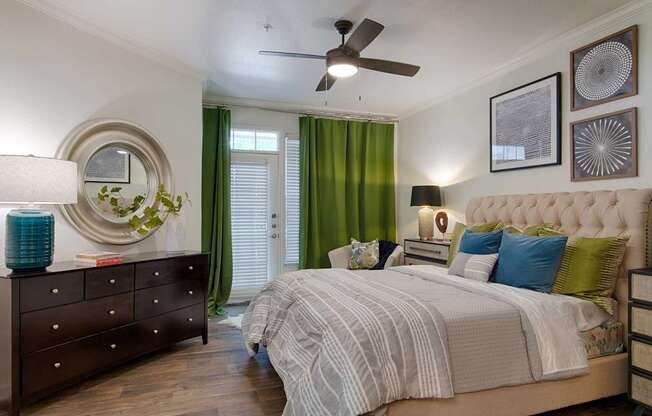 A bedroom with a large bed and a ceiling fan.