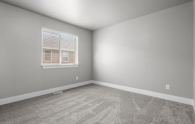 an empty room with a window and carpet