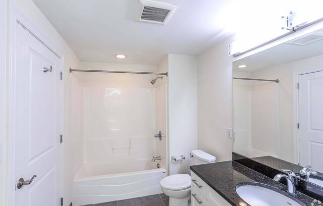 An updated bathroom with a black counter top and shower at 7 Cameron Apartments, Cambridge, MA, 02140