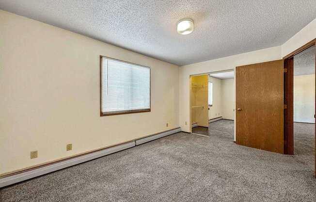 an empty living room with a door and a window