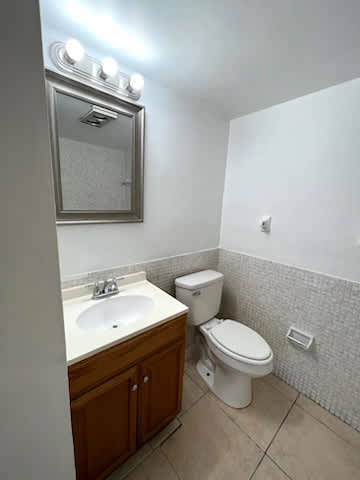 A white toilet sits next to a sink in a small bathroom.