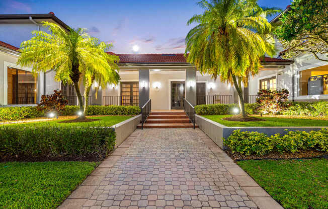 A house with a red roof and a brick pathway leading to the front door.