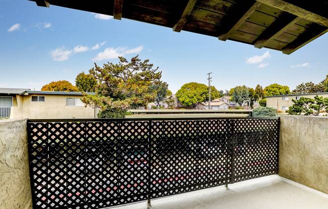 a balcony with a black fence and a view of the city