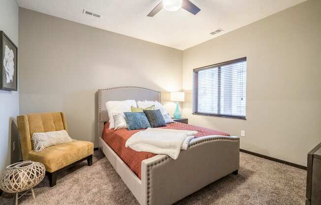Interiors-1 bedroom apartment bedroom with ceiling fan, queen bed and chair