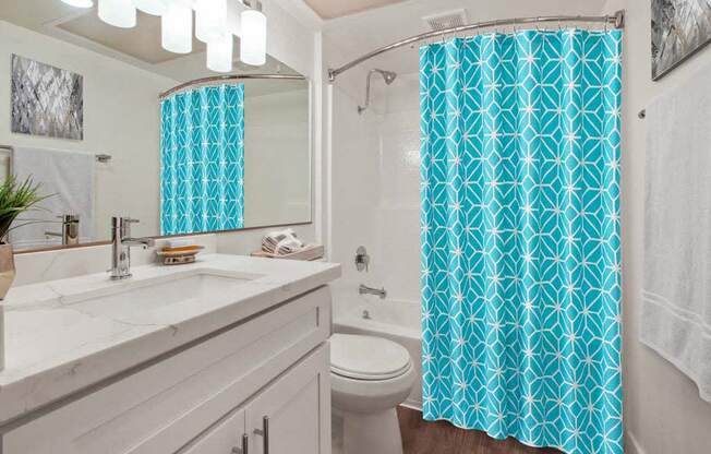 a bathroom with a white sink and a blue shower curtain  at Masselin Park West, Los Angeles, 90036 