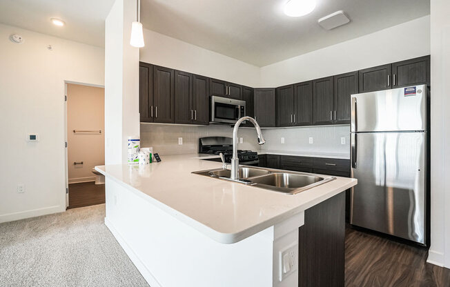 a kitchen with a large island and a stainless steel refrigerator at Meadowbrooke Apartment Homes, Michigan, 49512