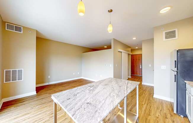 a dining room with a marble table and a kitchen with a refrigerator