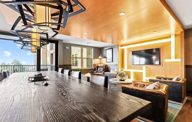 a long table with chairs and a tv in a room with a couch and a chair