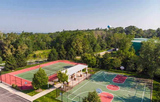 an aerial view of a basketball court and tennis court in a park