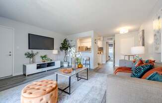 A living room with a grey couch and a white entertainment center.