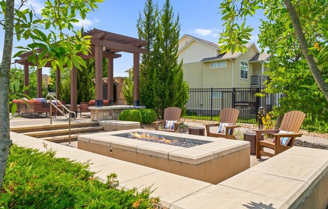 a patio with chairs and a fire pit      and a house