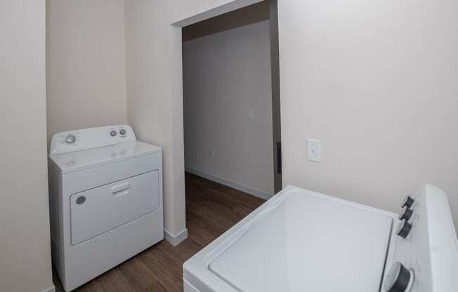 a white washer and dryer in a room with a door to a bathroom at The Crossings at Windsong, Arizona