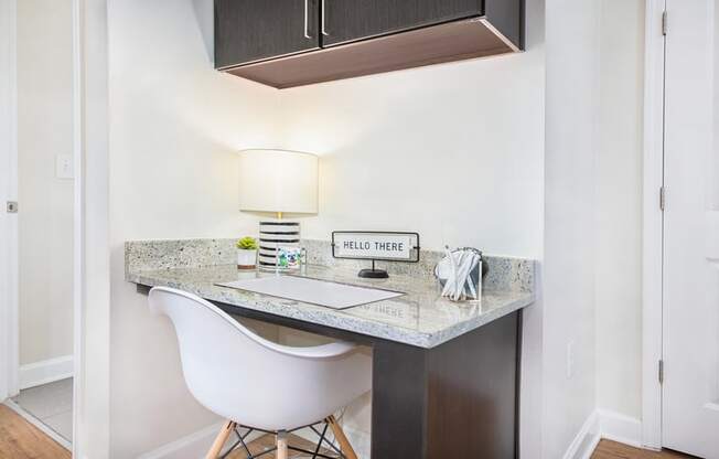 a small desk with a lamp and a chair in a home office