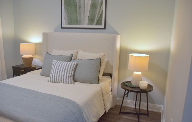 a bedroom with a bed and two lamps