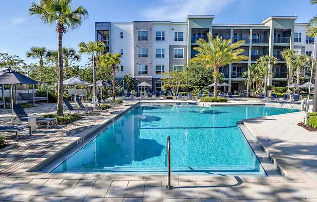 a swimming pool with an apartment building in the background