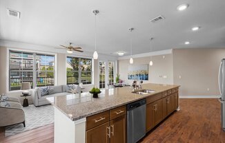a kitchen with a large island and a living room in the background at The Dorset, Kansas City, 64112
