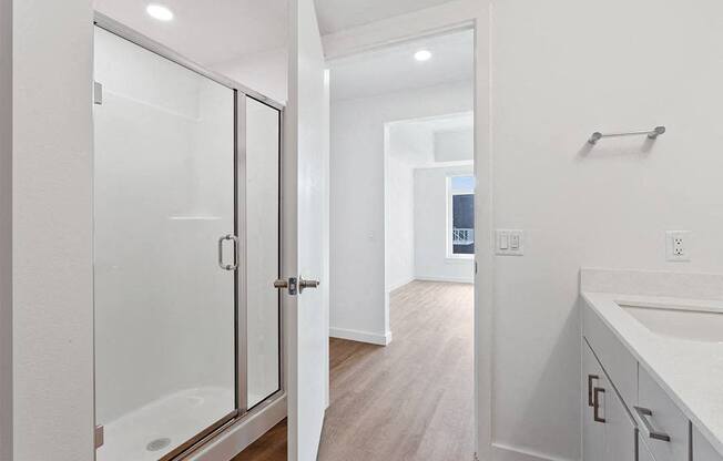 a white bathroom with a shower and a sink