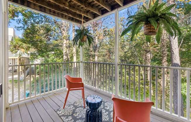 A balcony with a chair and a potted plant.