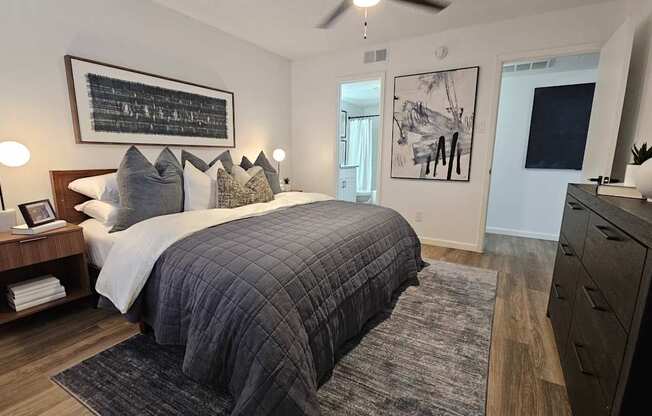 A bedroom with a large bed and a ceiling fan.
