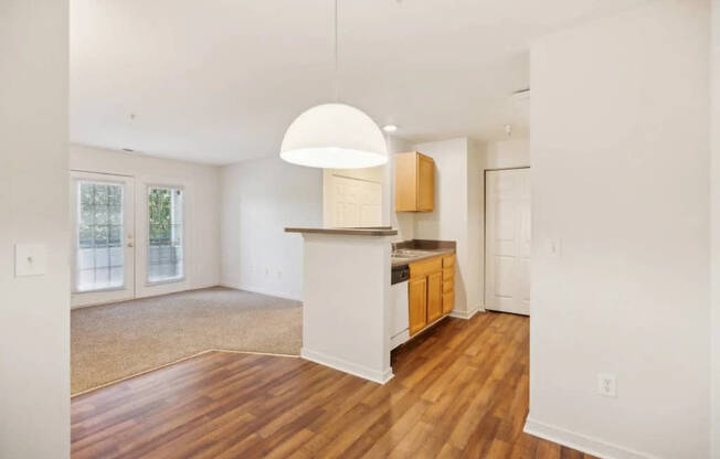A kitchen with wooden floors and white walls.