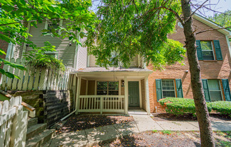 front entrance of a house with a porch and tree