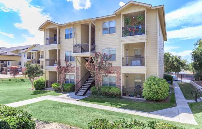 the outlook of an apartment building with lawns and trees