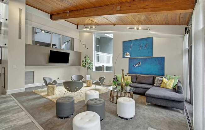 A living room with a grey couch and a wooden ceiling.