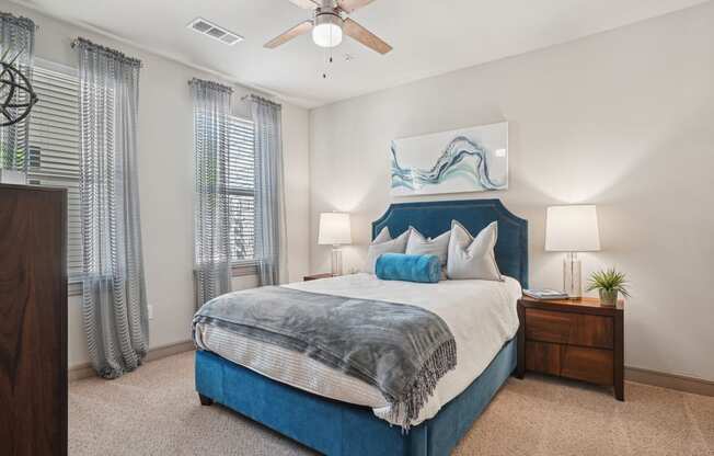 a bedroom with a blue and white bed and a ceiling fan