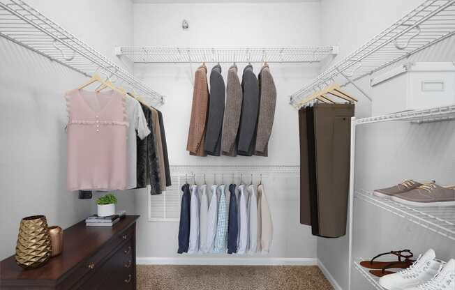A walk in closet with clothes