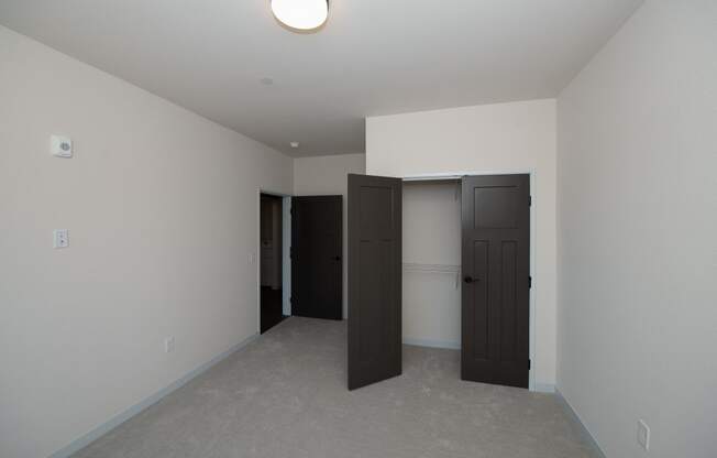 a bedroom with two doors and a closet at The Crossings at Windsong, Prescott Valley