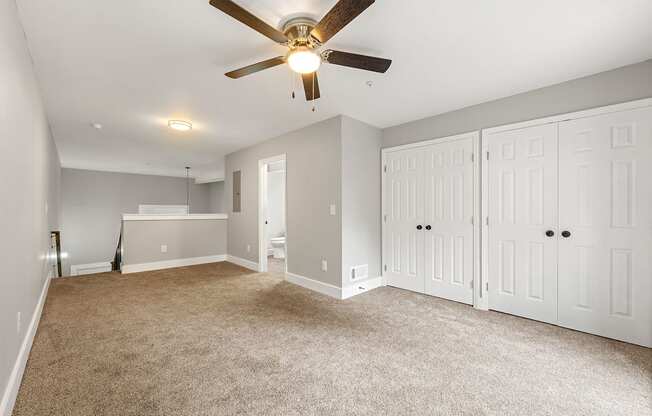 Master bedroom with a ceiling fan and white closet at Crogman School Lofts, Atlanta, 30315