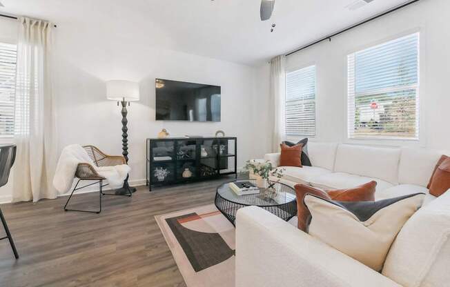 a living room with white couches and a tv