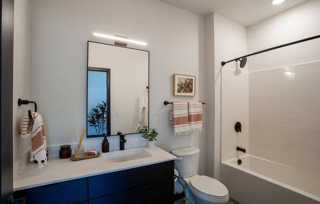 a bathroom with a large mirror and a toilet next to a bathtub