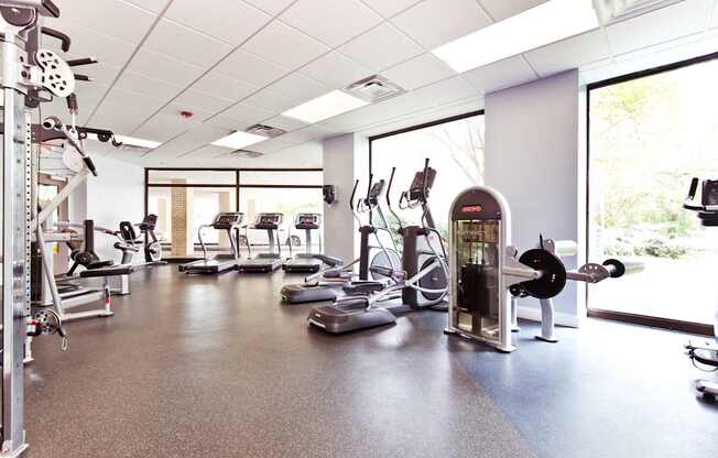 A gym with a variety of equipment including treadmills, weights, and exercise machines.
