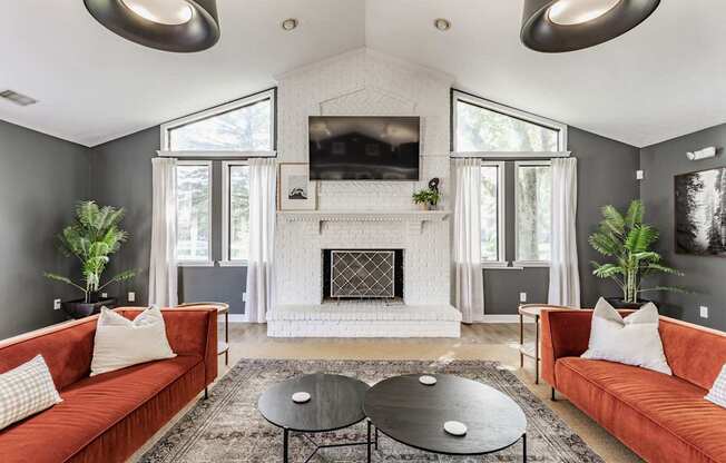 A living room with a fireplace and a television mounted above it