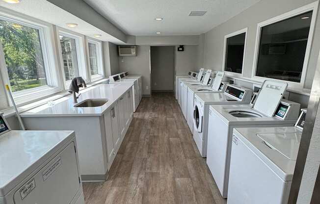 a laundry room with washes and dryers and a tv