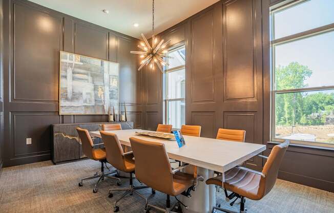 A conference room with a long table and chairs at The Ashton at East Park Apartments, Kennesaw, GA